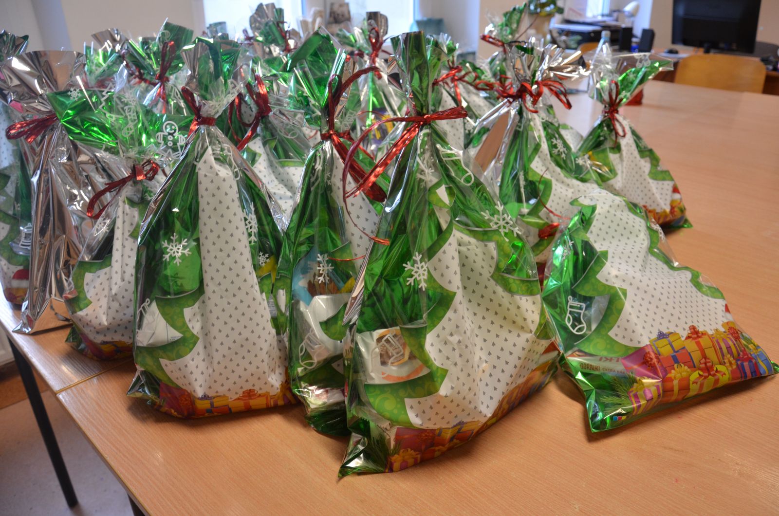 Na zdjeciu widać paczki przygotowane do rozdania mieszkankom w dniu św. Mikołaja. Słodycze są popakowane w kolorowe szeleszczące torebeczki świąteczne.