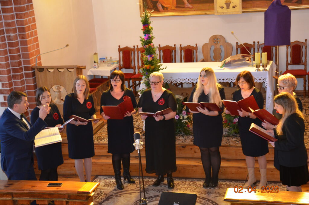 ołtarz główny w kościele parafialnym w Mierzeszynie. grupa 9 osób kobiet ubranych na czarno wyśpiewują pieśni wielkopostne