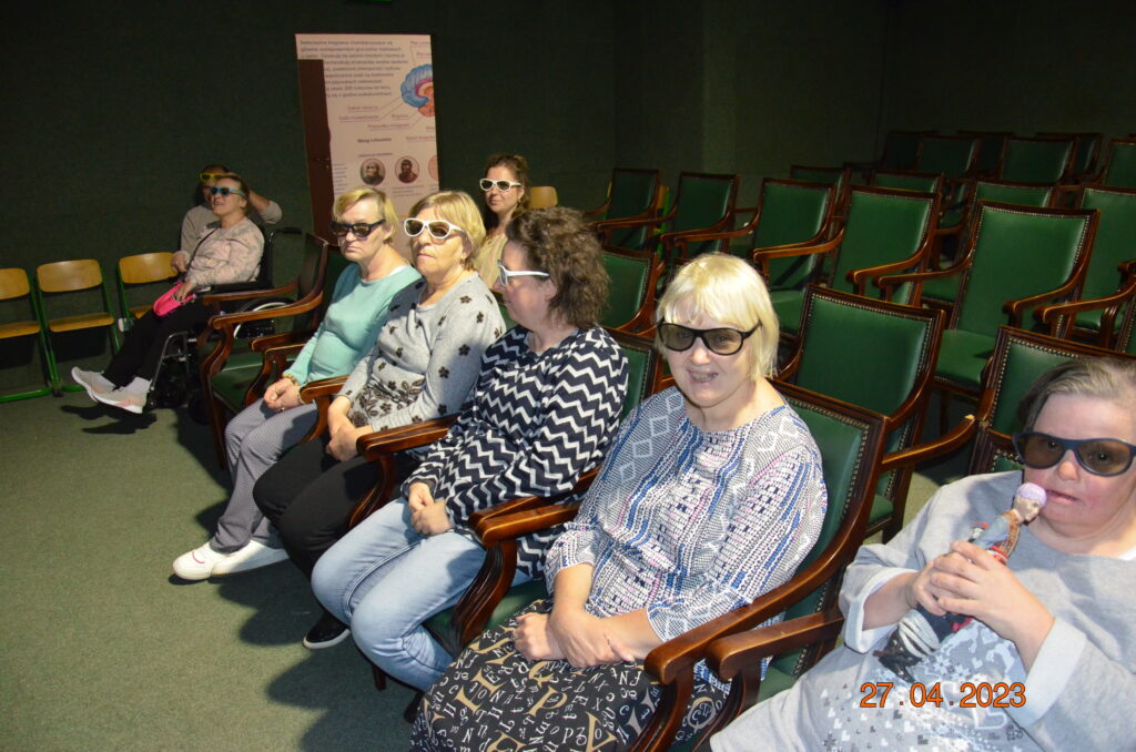 Grupa kilku pań  siedzi  w kinie , w okularach 3d