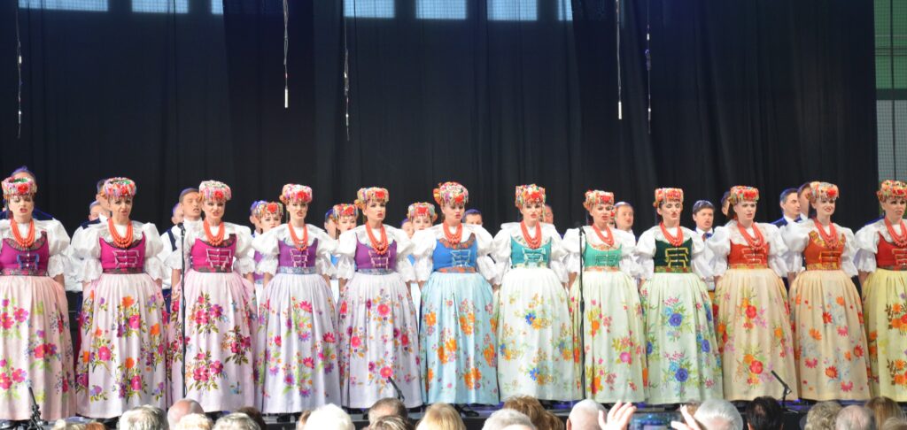 zespół tańca ślask na scenie. panie w kolorowych strojach śpiewają pieśni 