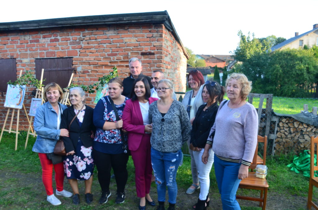 festyn jesienny w Mierzeszynie. Grupa 10 osób pozuje do zdjęcia, po środku uśmiecha się z fioletowym kombinezonie poseł Magdalena sroka