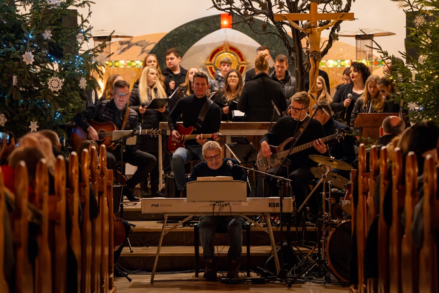Koncert kolęd, Główny ołtarz w Kościele, Na ołtarzu spora grupa osób grających na instrumentach. 