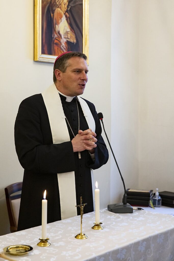 Kapica w Domu Pomocy społecznej. Przy ołtarzu stoi biskup Piotr Przyborek, udziela błogosławieństwa mieszkańcom, na ołtarzu biały obrus , dwie świece białe zapalone i krzyż po środku,