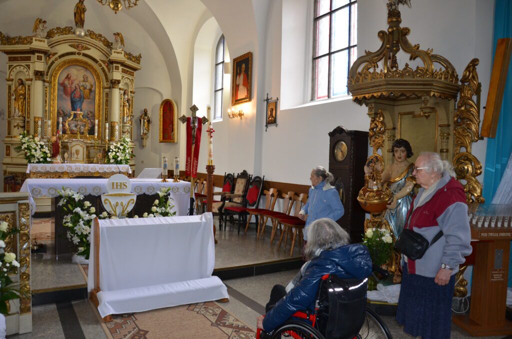 kościół 3 panie podziwiają wnętrze, jedna pani jest na wózku