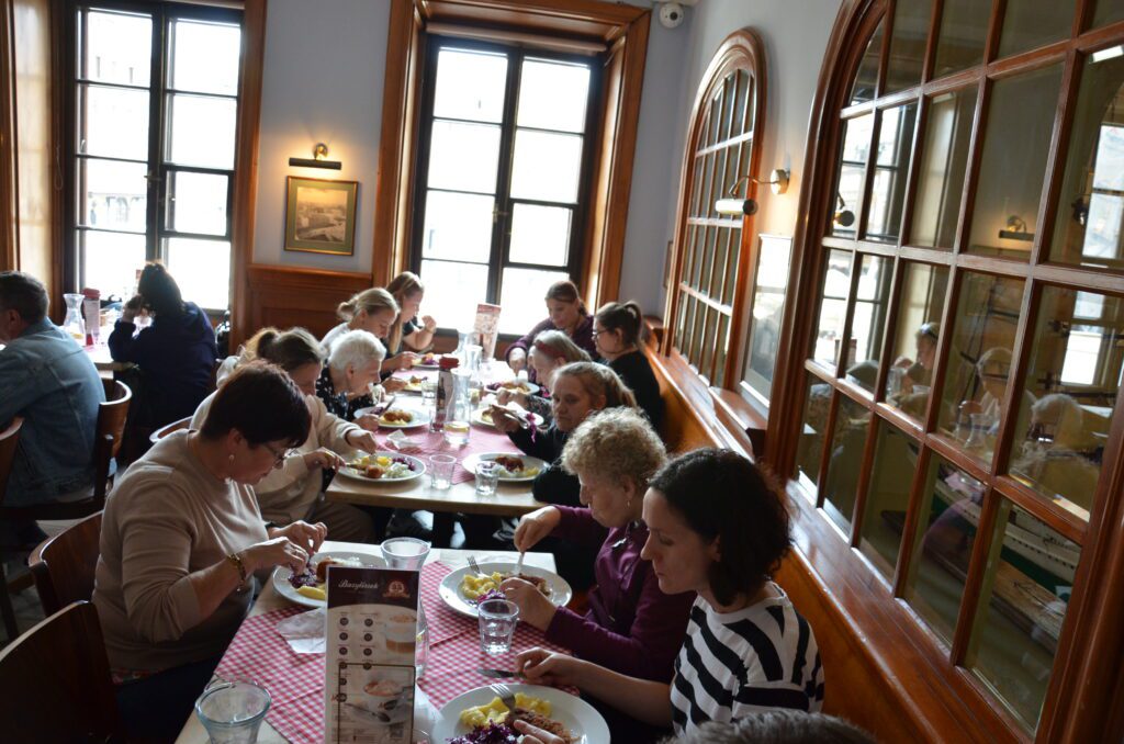 drewniane wykończenie, jedzą panie posiłek w restauracji