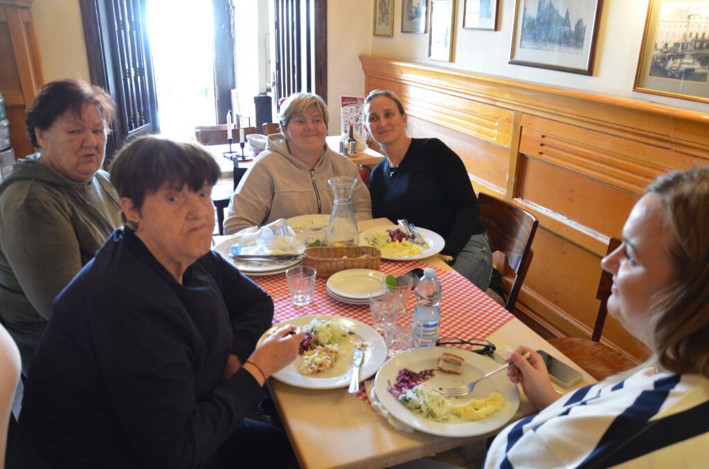 5 pań pozuje do zdjęcia podczas posiłku