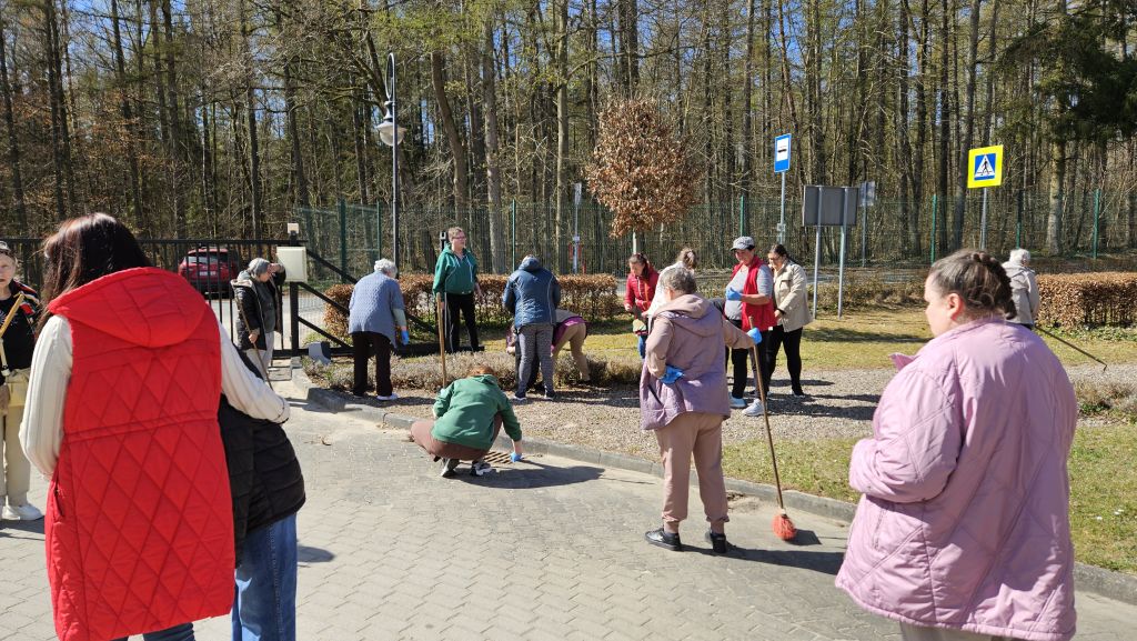 to samo miejsce, z innej perspektywy witac kobiety które są w trakcie zamiatania , grabienia, niektóre pochylone, 